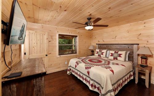 a bedroom with a bed and a ceiling fan at Breathtaking Cabin with Hot-tub, Fireplace and Games in Sevierville, Tennessee in Little Cove