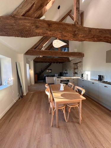 a dining room with a wooden table and chairs at Au 8 à Meursault, Magnifique maison Bourguignonne au pied des vignes, jardin, places de parking privée in Meursault