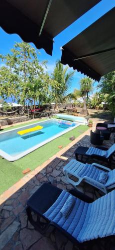 a group of lounge chairs next to a swimming pool at Location ST LEU CHEZ CARO in Étang