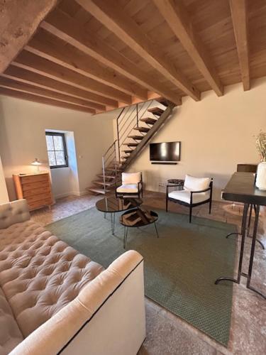 a living room with a couch and a staircase at Au 8 à Meursault, Magnifique maison Bourguignonne au pied des vignes, jardin, places de parking privée in Meursault