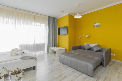 a living room with a couch and a yellow wall at Opera Passage Hotel & Apartments in Lviv