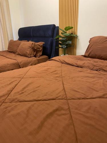 a bedroom with two beds and a blue couch at Orked Homestay Bagan Serai in Bagan Serai