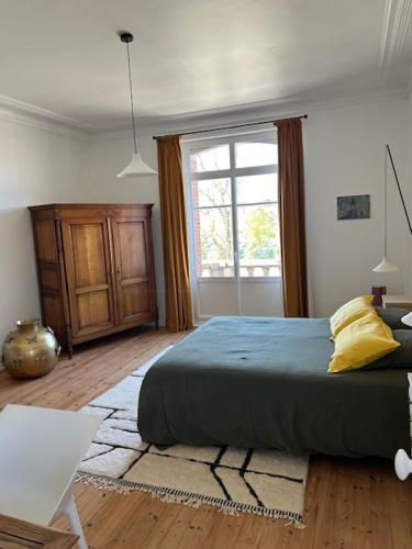 Un dormitorio con una cama grande y una ventana. en La Maison Ker Alinec, en Paimpol