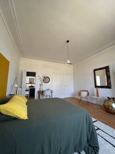 Un dormitorio con una cama con una almohada amarilla. en La Maison Ker Alinec, en Paimpol