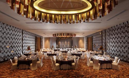 a ballroom with tables and chairs and a chandelier at RIMBA by AYANA Bali in Jimbaran