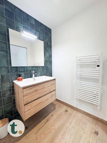 une salle de bain avec un lavabo et un miroir dans l'établissement Tranquiloue - Le Nid de Mary - 10min du PuyduFou, aux Herbiers