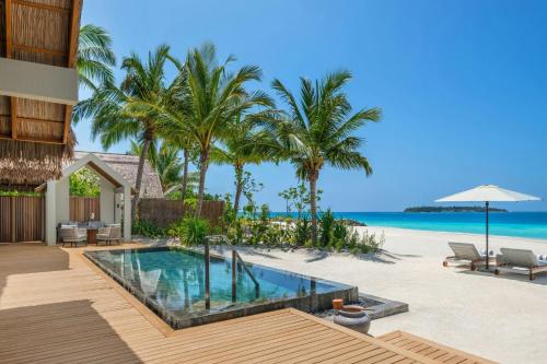 a villa with a swimming pool on the beach at JW Marriott Maldives Kaafu Atoll Island Resort in Male City
