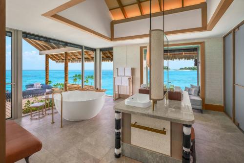 a bathroom with a tub and a view of the ocean at JW Marriott Maldives Kaafu Atoll Island Resort in Male City