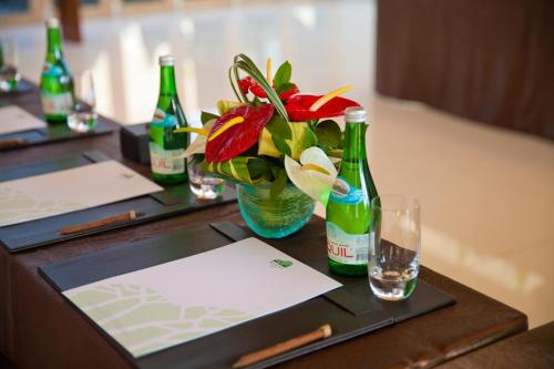 a table with two bottles and a vase with flowers at RIMBA by AYANA Bali in Jimbaran