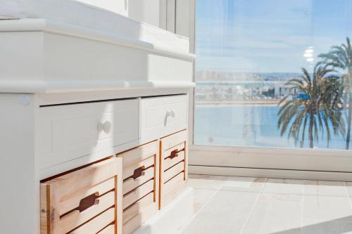 a kitchen with a sink and a window with a palm tree at Apartments Beach 4U - Can Pastilla in Can Pastilla