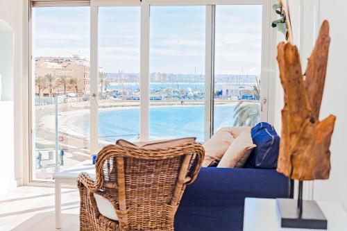 a living room with a blue couch and a large window at Apartments Beach 4U - Can Pastilla in Can Pastilla