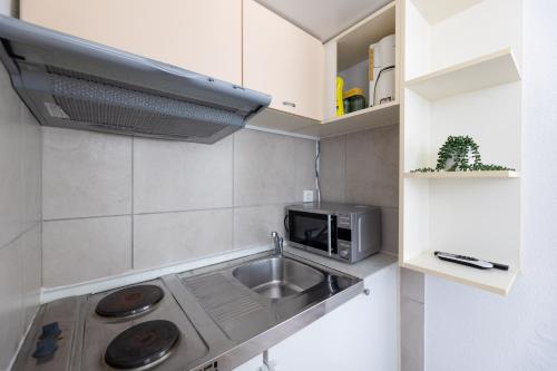 a kitchen with a sink and a microwave at Villa Okruk-10 meters away from the beach in Trogir
