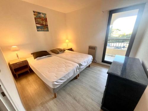 une chambre avec un grand lit et une grande fenêtre dans l'établissement Appartement 2P, 4 Couchages, Terrasse et Salon de Jardin à 200m de la Plage, Fréjus - FR-1-226A-22, à Fréjus