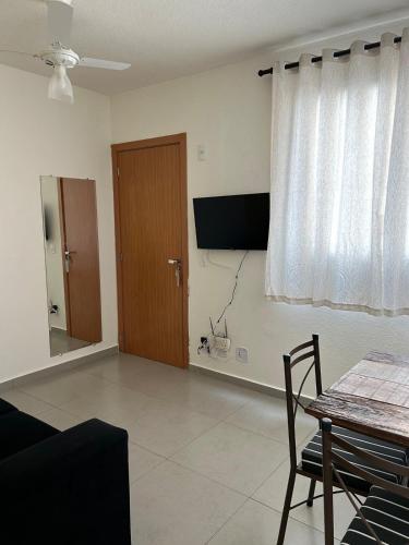 a living room with a table and a window at Apto Aconchegante Catanduva V in Catanduva