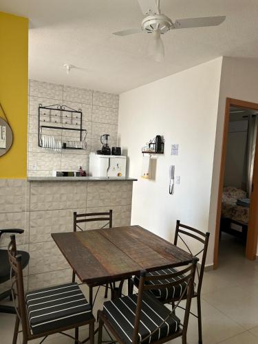 a dining room with a table and chairs and a kitchen at Apto Aconchegante Catanduva V in Catanduva
