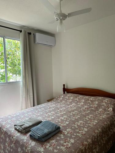 a bedroom with a bed with two towels on it at Apto Aconchegante Catanduva V in Catanduva