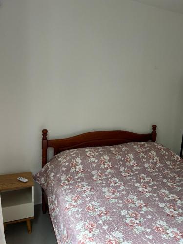 a bedroom with a bed and a table with a bedspread at Apto Aconchegante Catanduva V in Catanduva