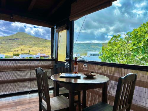 a table and chairs on a balcony with a bottle of wine at Casa Rural "La Molina" in Máguez