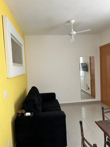 a black couch in a living room with a ceiling at Apto Aconchegante Catanduva V in Catanduva
