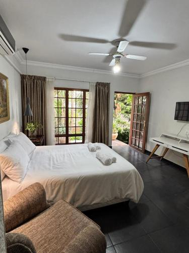 a bedroom with a large bed and a ceiling fan at Ben & Bern House in Krugersdorp