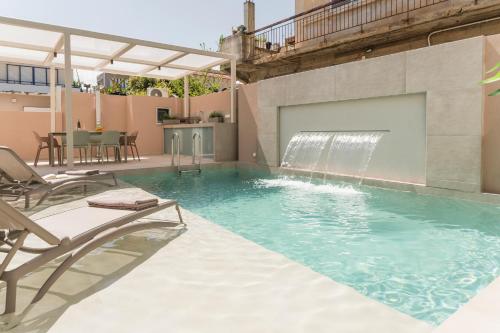 a swimming pool with a waterfall in a house at Orama Luxury Apartments in Nea Kydonia