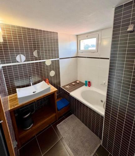 une salle de bain avec un lavabo et une baignoire dans l'établissement La Family House - Calme & Spacieuse, 20mn Plages & Montpellier, à Vendargues