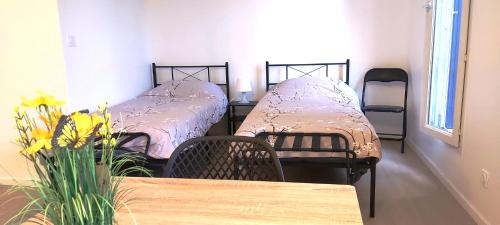 - 2 lits jumeaux dans une chambre avec une table dans l'établissement Home near to Paris, aeroport, Eurodisney, à Les Pavillons-sous-Bois