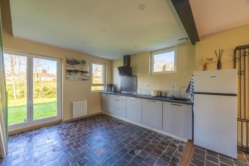 a kitchen with a refrigerator and some windows at Le Petit Pré in Saonnet