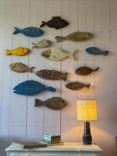 a wall with many fish hanging on it at LA FERME DE NEHOU in Gatteville-le-Phare