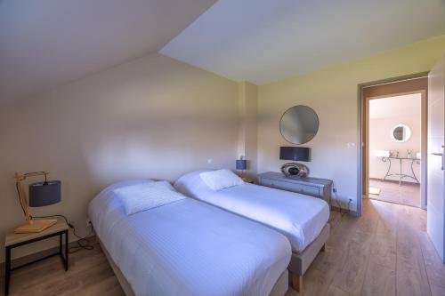 a bedroom with two beds and a mirror at Le Petit Pré in Saonnet