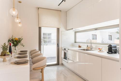 a white kitchen with a counter and a sink at Orama Luxury Apartments in Nea Kydonia