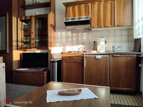 a kitchen with wooden cabinets and a bowl on a table at Haus Ausreißer 2 - Hafennest in Bensersiel