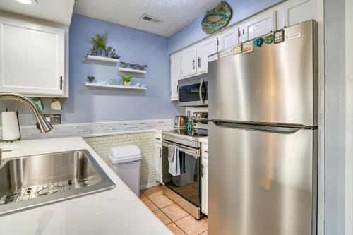a kitchen with a stainless steel refrigerator and white cabinets at 2 Mi to Silver Dollar City Cozy Condo with Balcony! in Branson West