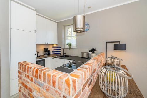 a kitchen with a brick wall in the middle at Anker Hus in Westerland (Sylt)