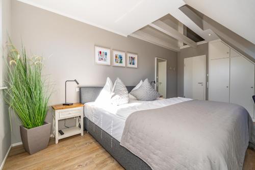a bedroom with a large bed and a plant at Anker Hus in Westerland (Sylt)