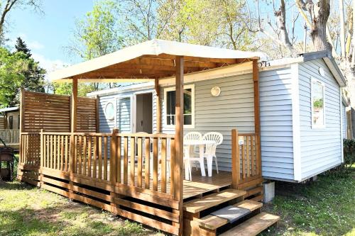 une petite maison avec une terrasse couverte et un kiosque dans l'établissement Mobile Home Camping Parc des Sept Fonts B271, à Agde