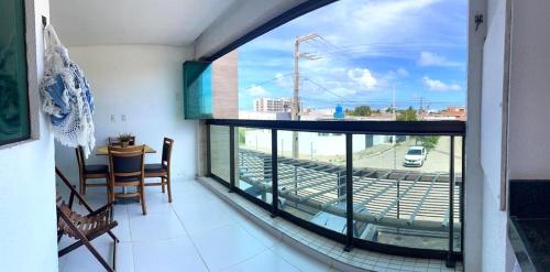 a balcony with a large window with a view of a street at Varanda Gourmet Diversão Pet Praia do Francês in Praia do Frances