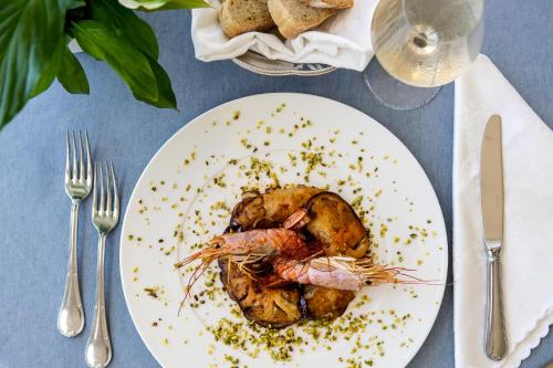 a plate of food with a shrimp on a table at Hotel Villaggio Stromboli in Santa Domenica