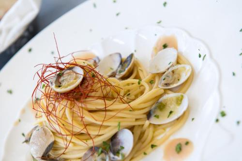 a plate of pasta with shrimp and oysters on it at Hotel Villaggio Stromboli in Santa Domenica