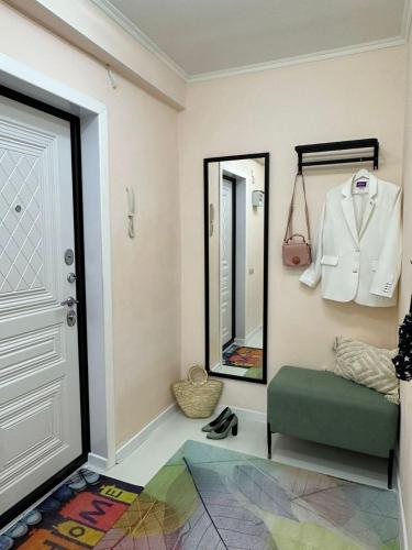 a dressing room with a mirror and a green ottoman at Уютный уголок кв 54 in Shymkent