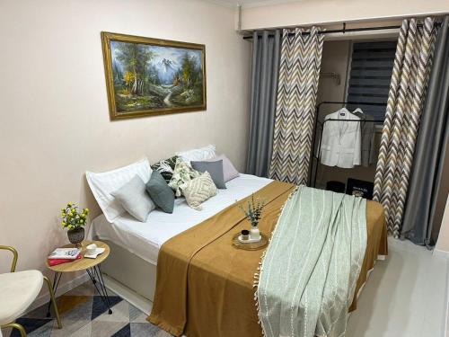 a small bedroom with a bed with a yellow blanket at Уютный уголок кв 54 in Shymkent
