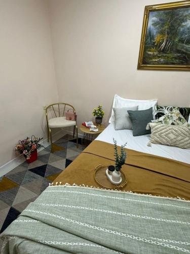a bedroom with a large bed and a chair at Уютный уголок кв 54 in Shymkent
