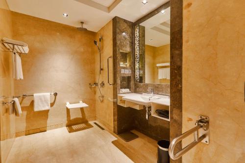 a large bathroom with a sink and a shower at Crowne Plaza New Delhi Rohini by IHG in New Delhi
