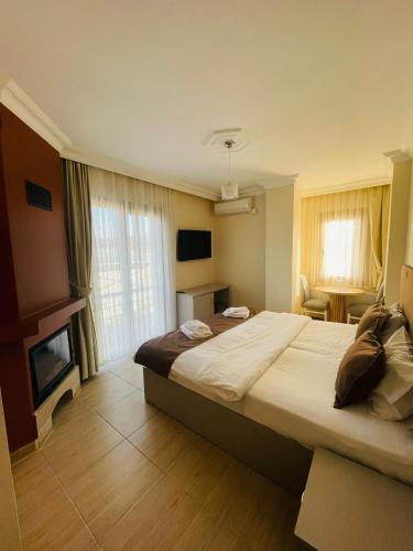 a hotel room with a large bed and a fireplace at Ağva Manolyam Otel in Sile