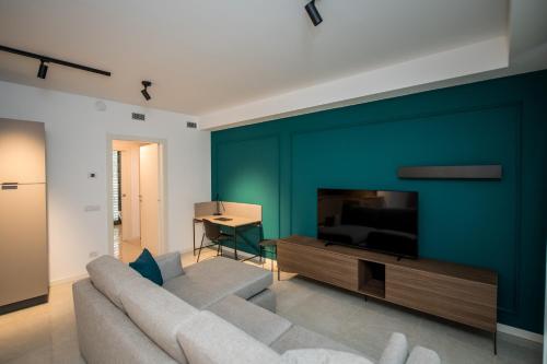 a living room with a couch and a television at Compagnoni Suite Luxe - Spa & Wellness in Milan