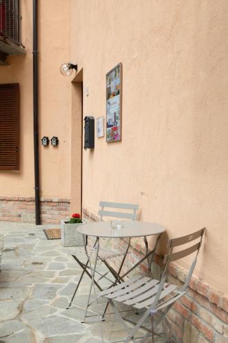 a table and two chairs sitting next to a wall at Casa Graziella- appartamenti vacanze in Portacomaro