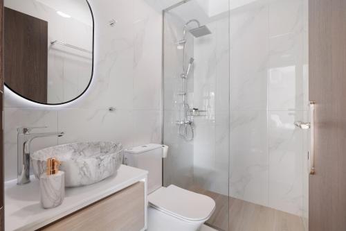 une salle de bain avec toilettes, lavabo et miroir dans l'établissement Plaka Studios 2, à Benitses