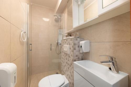 a bathroom with a toilet and a sink and a shower at Villa Okruk-10 meters away from the beach in Trogir