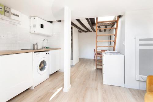 - une cuisine avec lave-linge et sèche-linge dans la chambre dans l'établissement Sainte-Anne - KP - Cosy modern apartment, à Paris