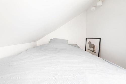 une chambre avec un lit blanc avec une photo d'un cerf dans l'établissement Sainte-Anne - KP - Cosy modern apartment, à Paris